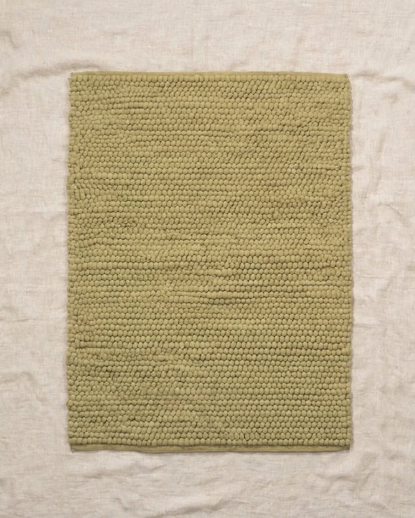Sage Green Chunky Wool Area Rug, handmade in Bhadohi India – a rectangular, handwoven wool rug in a muted sage green color, laid flat on a