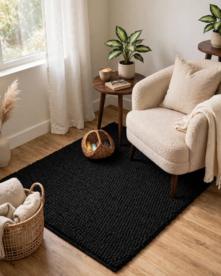 Charcoal Black Chunky Wool Area Rug, handmade in Bhadohi India – a black textured woven area rug styled in a bright, modern living room corner