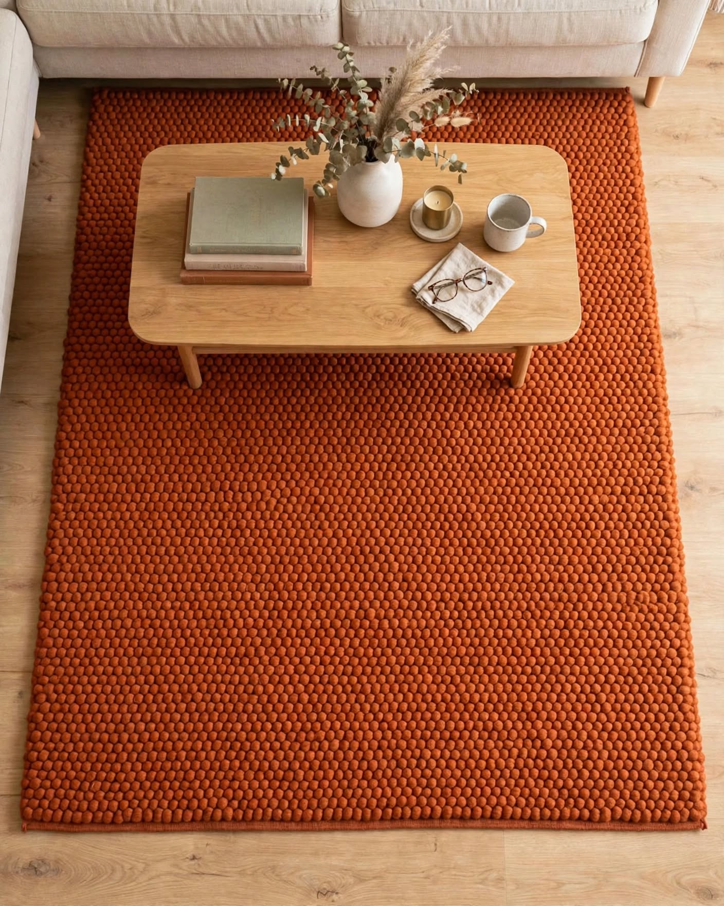 Terracotta Rust Chunky Wool Area Rug, handmade in Bhadohi India – a large textured orange-brown area rug in a modern living room setting, styled