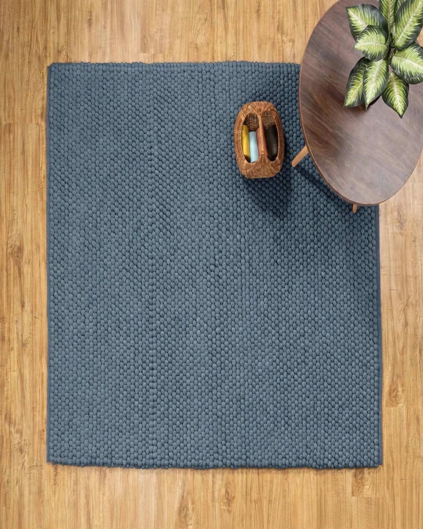 Denim Blue Chunky Wool Area Rug, handmade in Bhadohi India – a textured charcoal gray woven area rug laid out on a light wood floor, styled