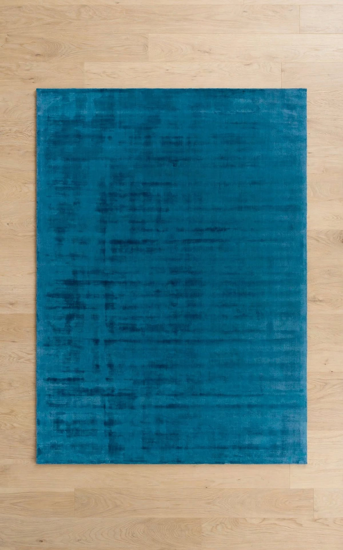 Blue Silky Viscose Rug, handmade in Bhadohi India – a rectangular blue area rug with a subtle distressed texture, laid flat on a