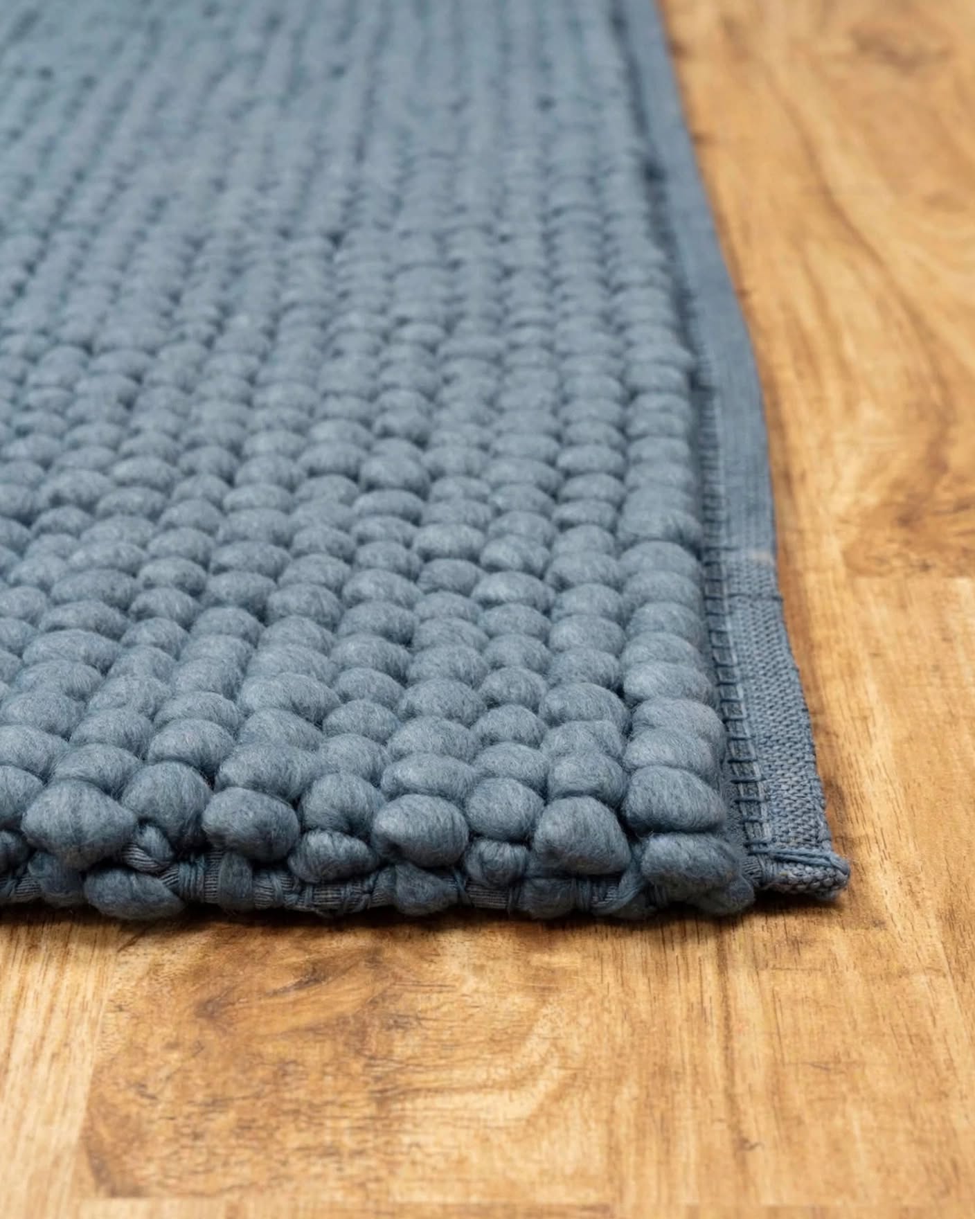 Denim Blue Chunky Wool Area Rug, handmade in Bhadohi India – a close-up of a textured, chunky woven rug in a muted slate blue-gray color,