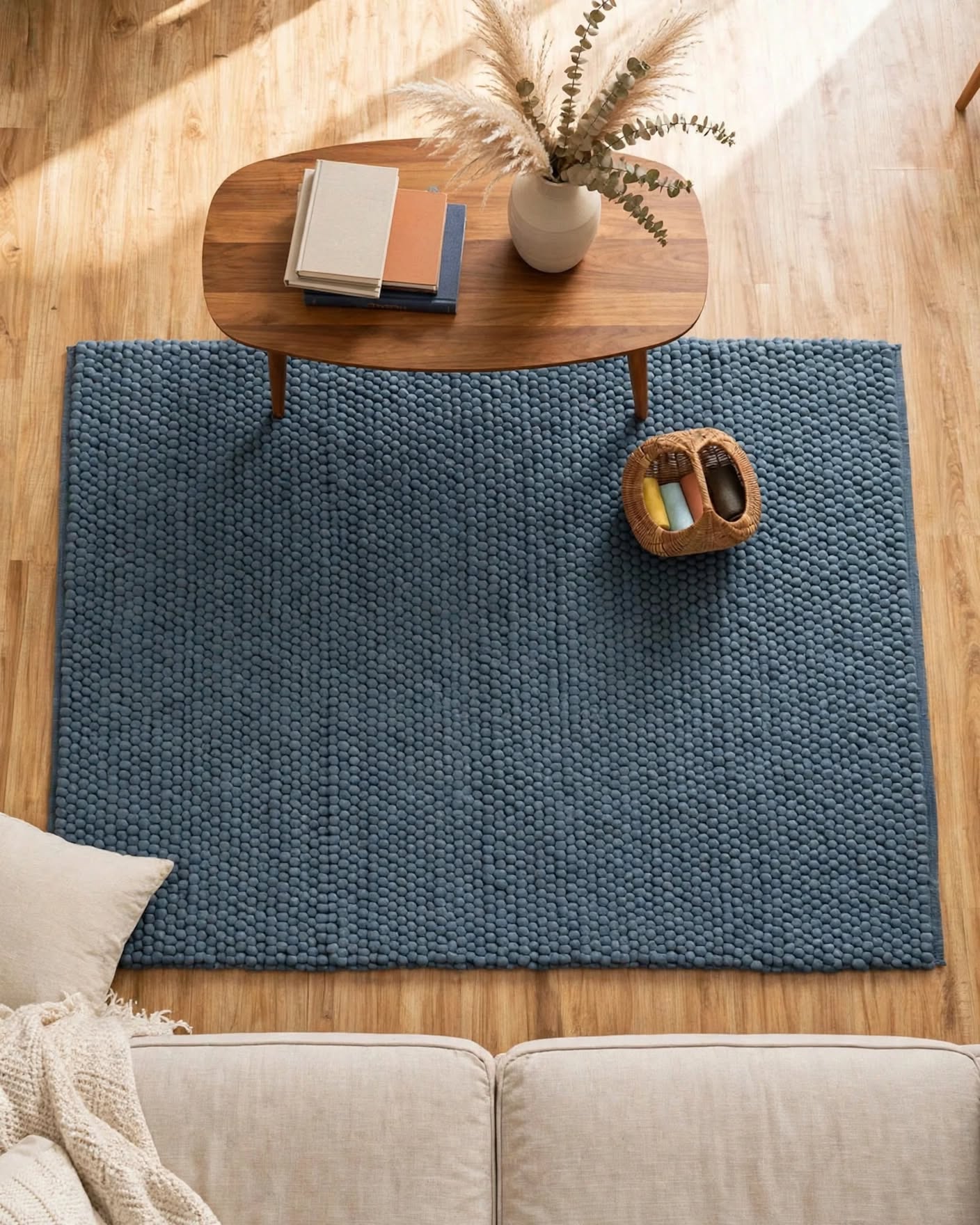 Denim Blue Chunky Wool Area Rug, handmade in Bhadohi India – a textured blue area rug laid out on a light wood floor in a living room